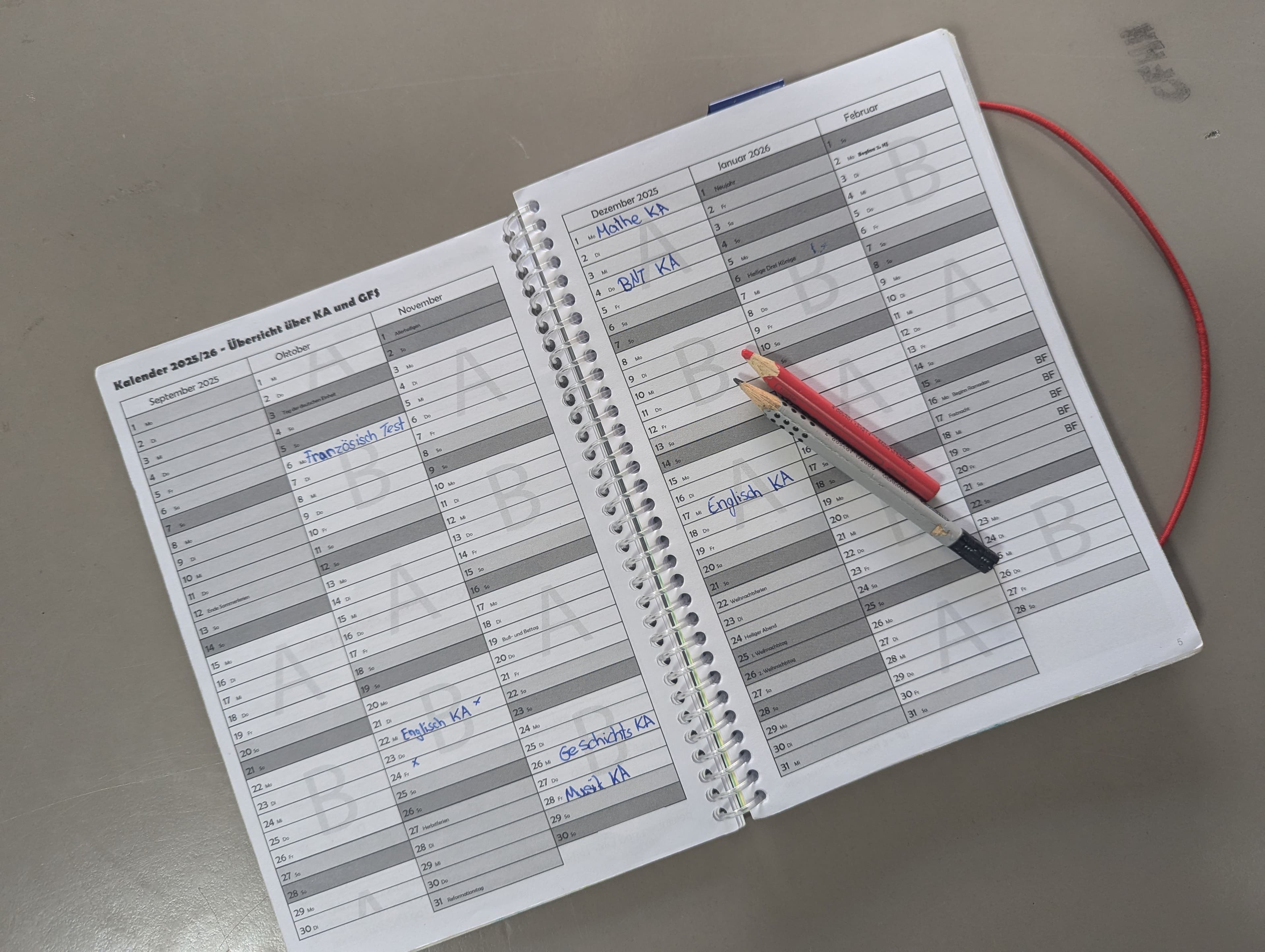 a calendar with a pink pin on it and a pencil .