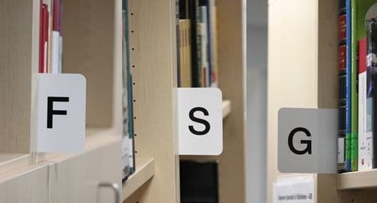 a row of bookshelves with labels on them that say f , s , and g .