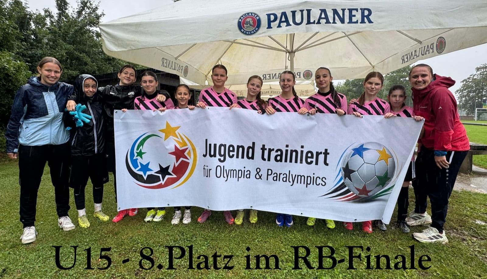 A girls' soccer team and coaches hold a banner reading "Jugend trainiert für Olympia & Paralympics" with a star-patterned soccer ball logo. Text on image: "U15 - 8.Platz im RB-Finale".