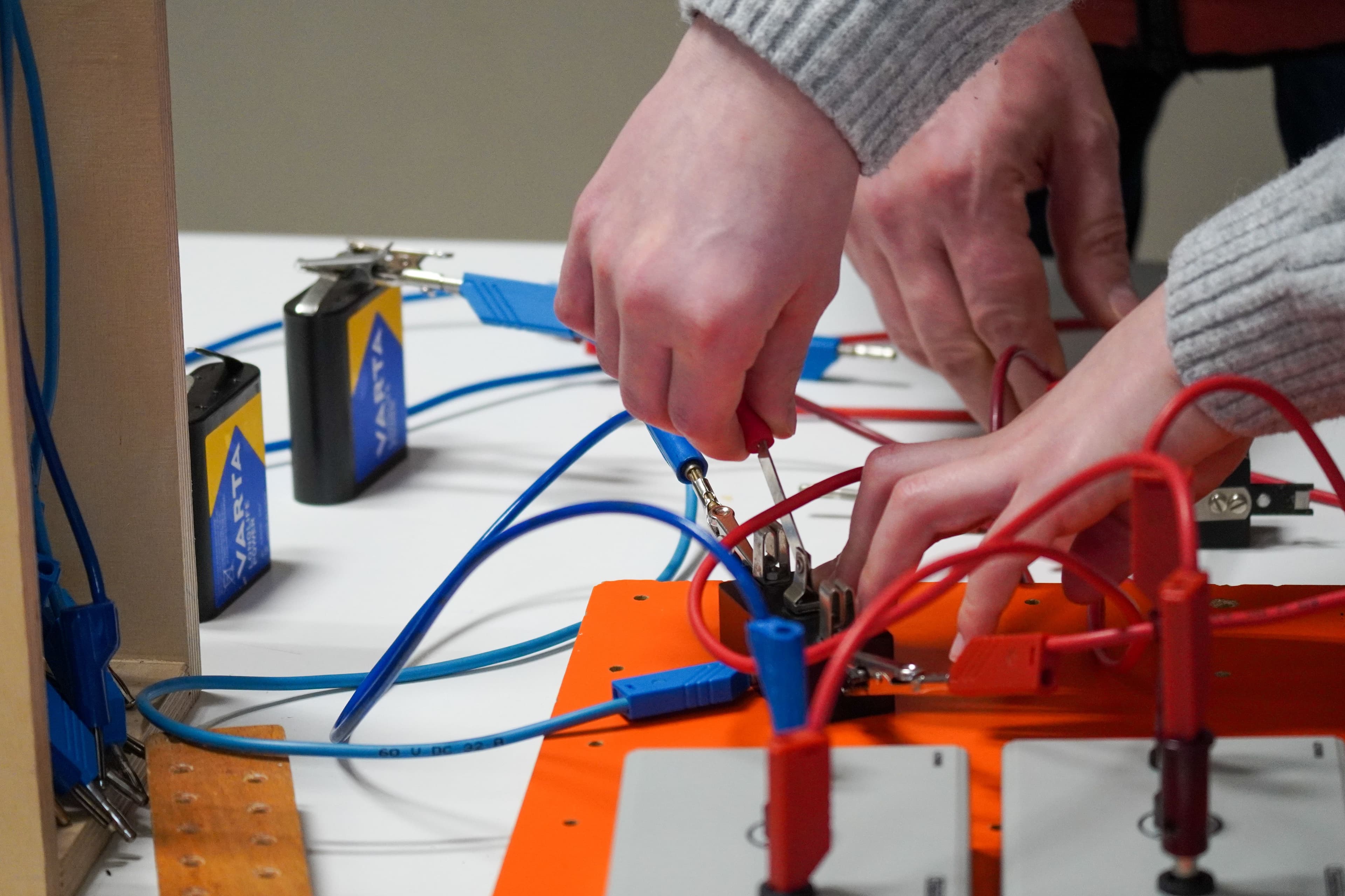 a group of people are working on a circuit board .