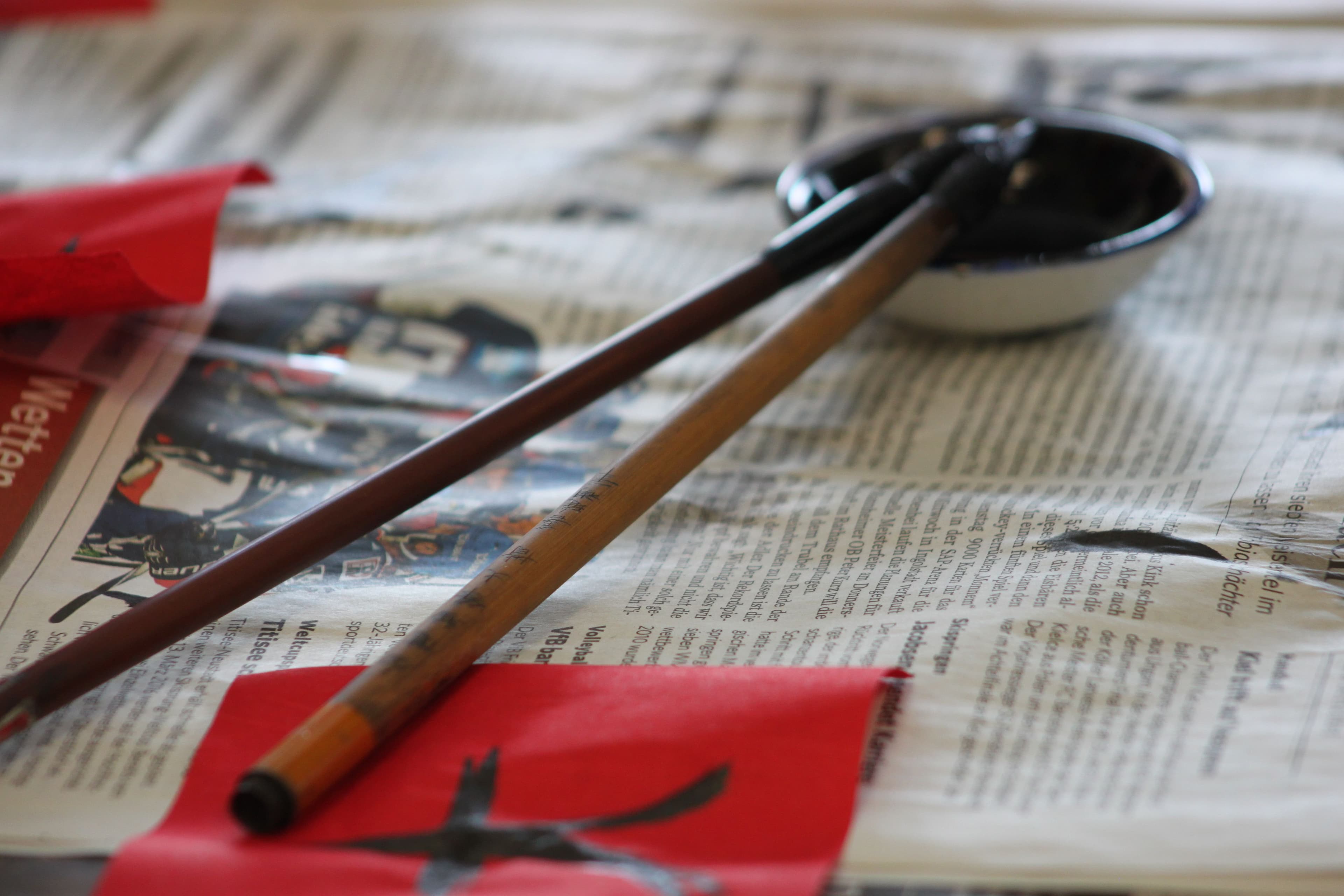 Chinesische Kalligraphie-Pinsel auf Zeitungspapier.
