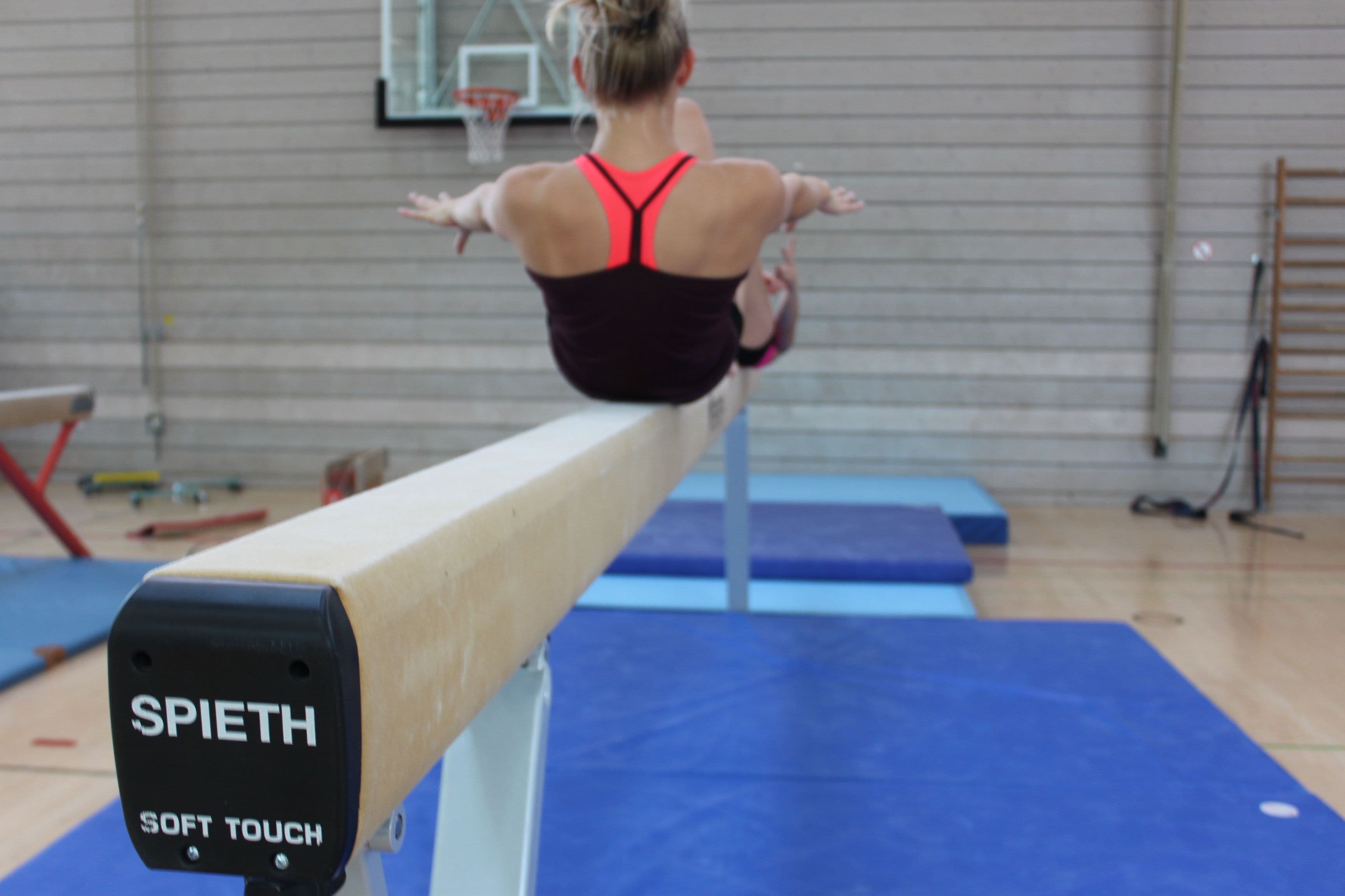 Turnerin in einer Pose auf dem Balken.