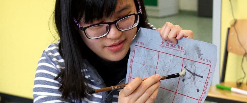 Chinesische Lehrerin erklärt die Wasser-Kalligraphie