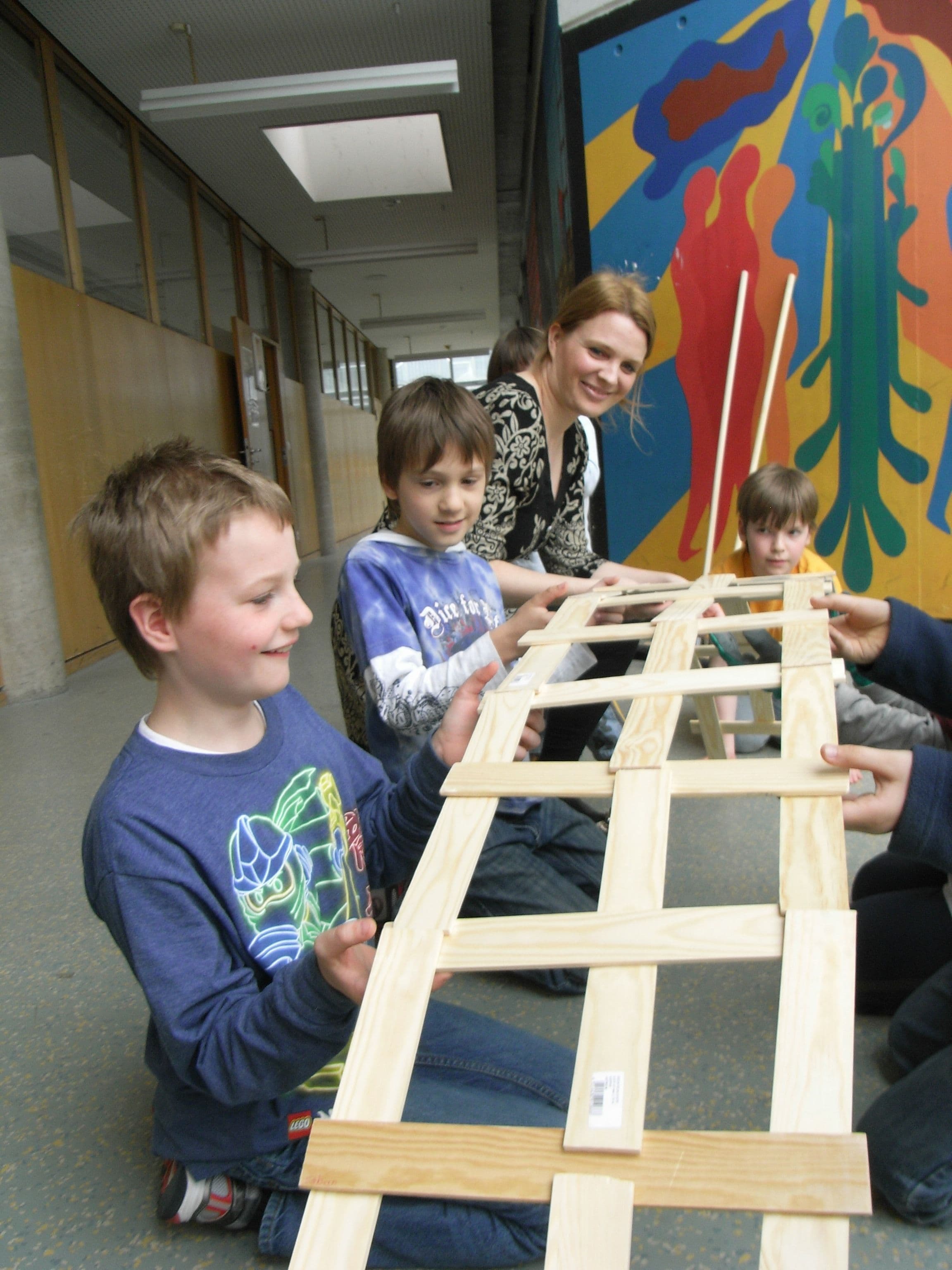 mehrere Kinder arbeiten gemeinsam an einer Brücke
